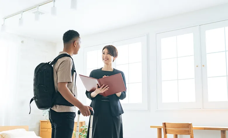 打ち合わせをしているスタッフとリュックを背負った男性の様子