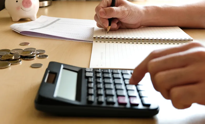 電卓とメモを使って計算している手元の様子